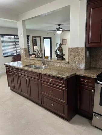 a kitchen with granite countertop a sink and cabinets