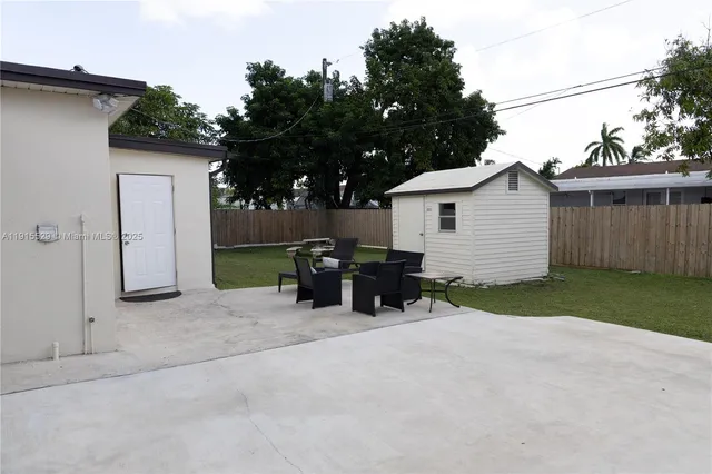 a view of a house with backyard and trees