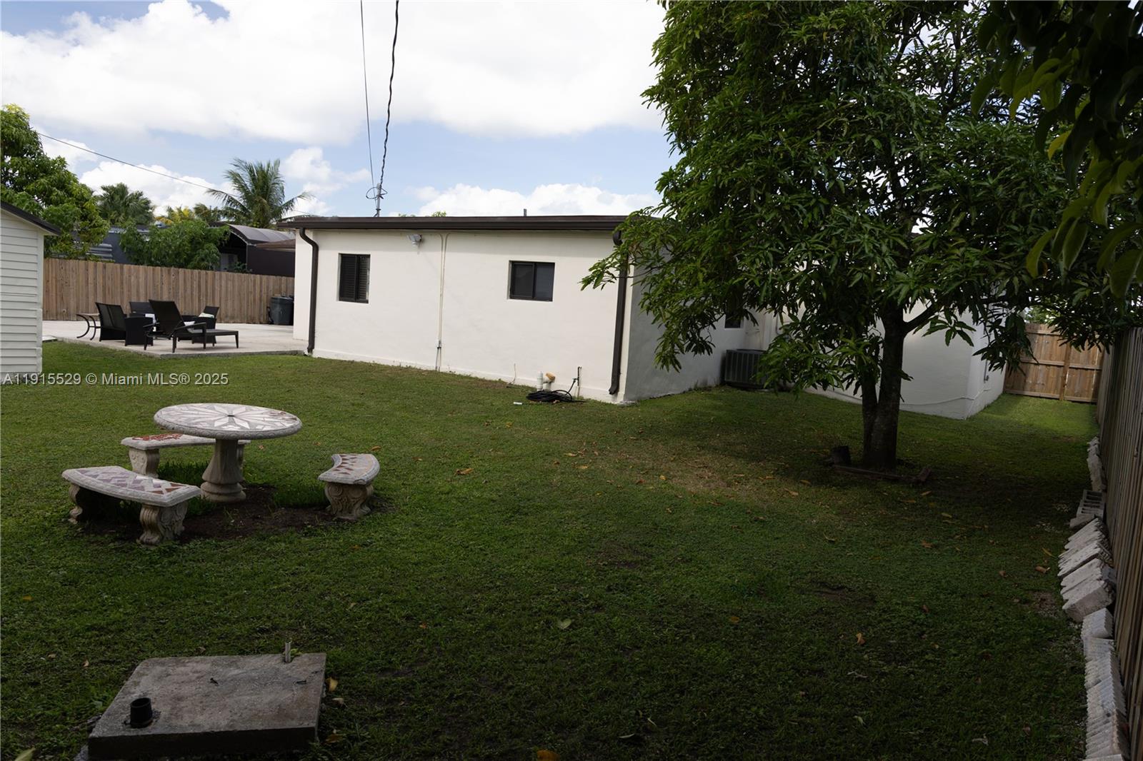 14280 Southwest 285th Street, Unit A Homestead, FL 33033 - Photo 5 of 18 a view of a backyard with table and chairs plants and large tree