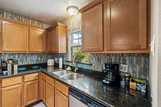 a kitchen with stainless steel appliances granite countertop a sink stove and cabinets