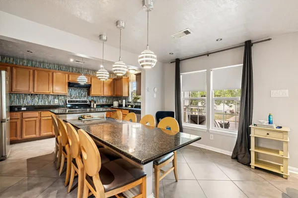 a dining table with chairs and kitchen view