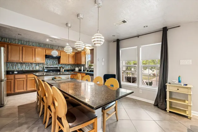 a dining table with chairs and kitchen view
