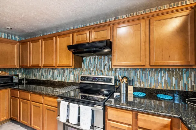 a kitchen with granite countertop a sink and a black wooden cabinets