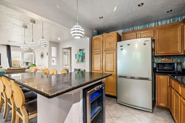 a kitchen with stainless steel appliances granite countertop a refrigerator a sink and a stove