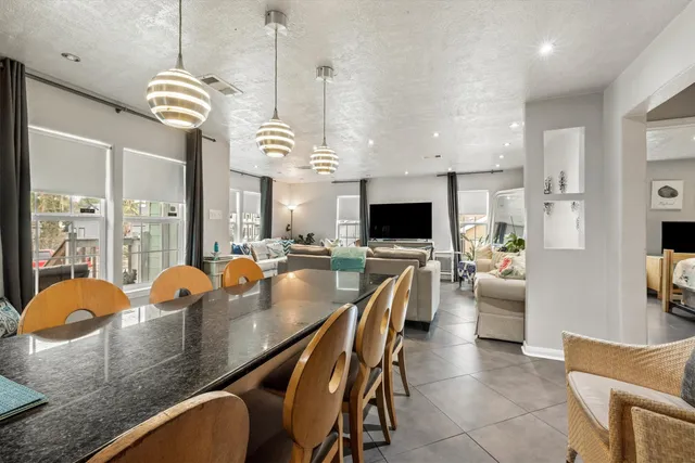 a dining room filled chandelier and wooden furniture