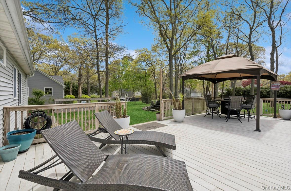 85 Old Stone Road Calverton, NY 11933 - Photo 11 of 19 a view of a patio with a table chairs and a fire pit