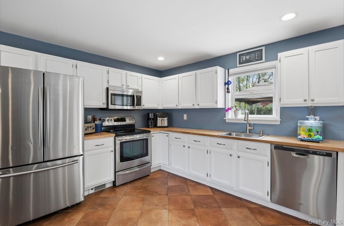 85 Old Stone Road Calverton, NY 11933 - Photo 19 of 19 a kitchen with white cabinets stainless steel appliances and a window