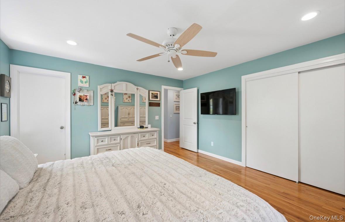 85 Old Stone Road Calverton, NY 11933 - Photo 5 of 19 a bedroom with a large bed and a chandelier