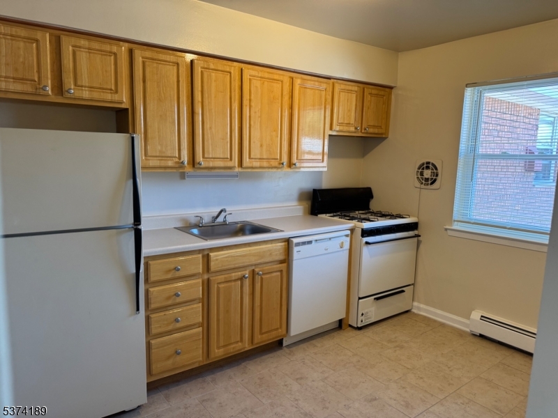 63 Traphagen Road, Unit B Wayne, NJ 07470 - Photo 13 of 18 a kitchen with white cabinets and white appliances
