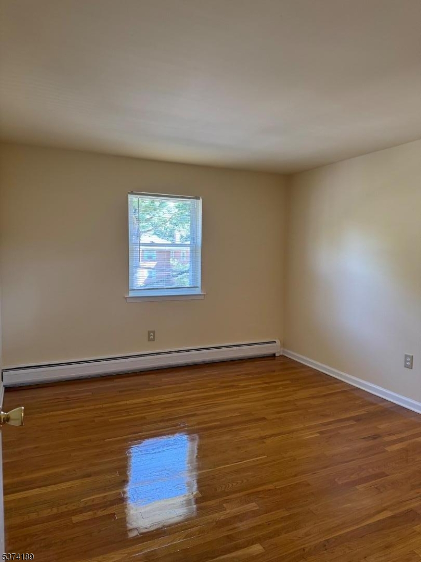 63 Traphagen Road, Unit B Wayne, NJ 07470 - Photo 5 of 18 an empty room with wooden floor and windows