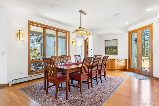 a dining room with furniture a chandelier and wooden floor