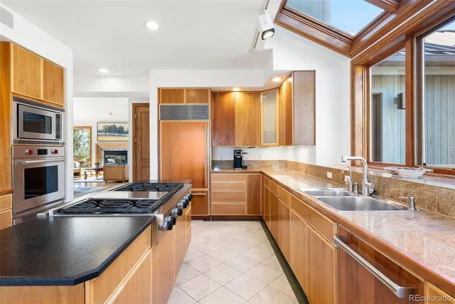 a kitchen with stainless steel appliances granite countertop a sink a stove and a refrigerator