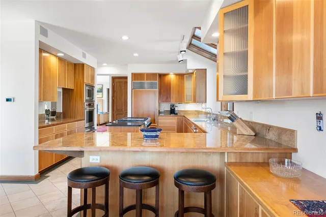 a kitchen with a sink a counter and chairs