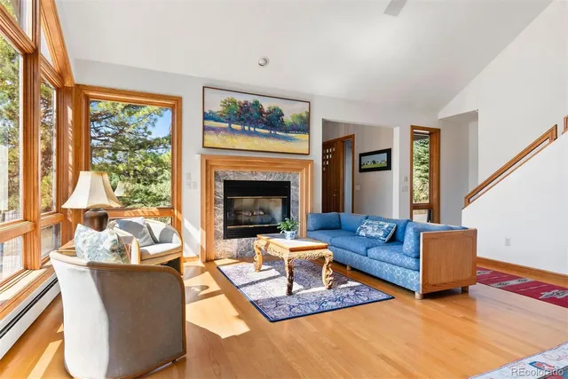 a living room with furniture fireplace and a large window