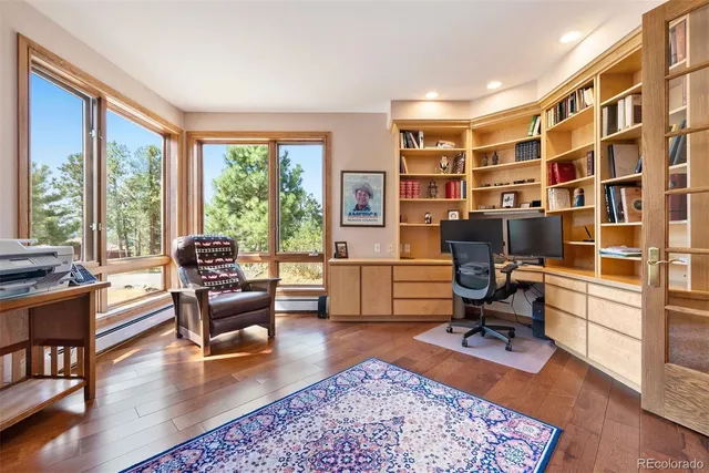 a view of a livingroom with workspace and a window