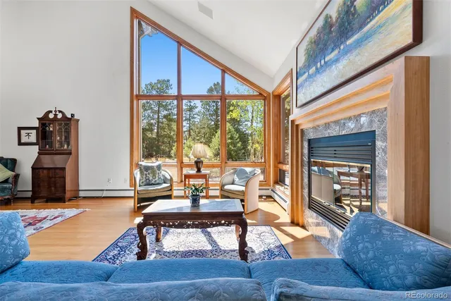 a living room with furniture large window and wooden floor