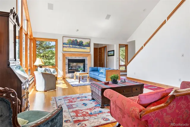 a living room with furniture fireplace and a large window