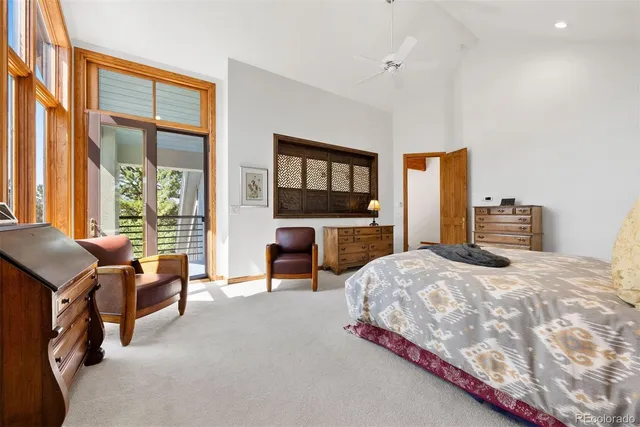 a bedroom with a bed flat screen tv and a large window