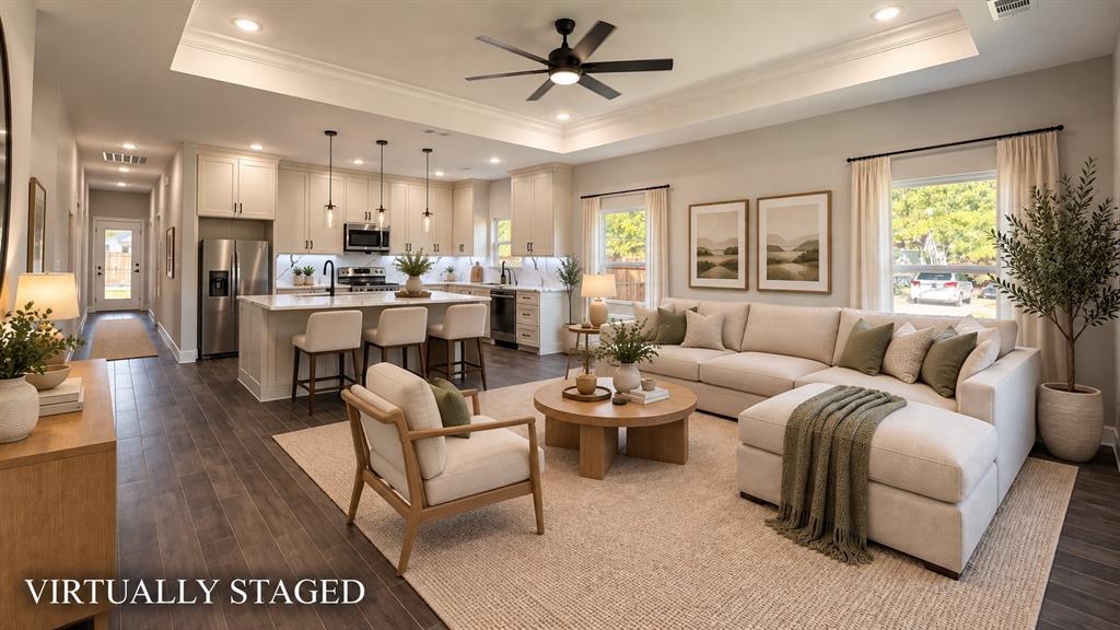 302-304 West Pine Street Whitewright, TX 75491 - Photo 12 of 38 Open-concept living space featuring wood-finish flooring, a tray ceiling with recessed lighting, and a kitchen island with pendant lighting