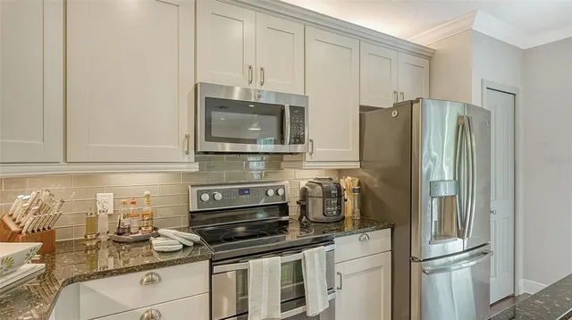 a kitchen with stainless steel appliances a refrigerator stove and microwave