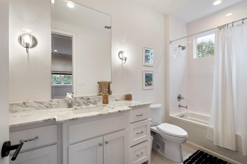 6605 Robin Road Dallas, TX 75209 - Photo 20 of 28 a bathroom with a granite countertop toilet a sink a mirror a vanity and shower