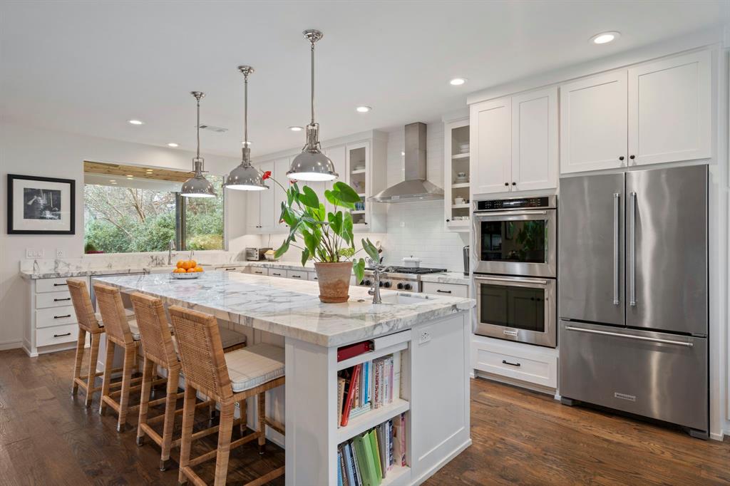 6605 Robin Road Dallas, TX 75209 - Photo 8 of 28 a kitchen with kitchen island a refrigerator a stove a sink and white cabinets with wooden floor
