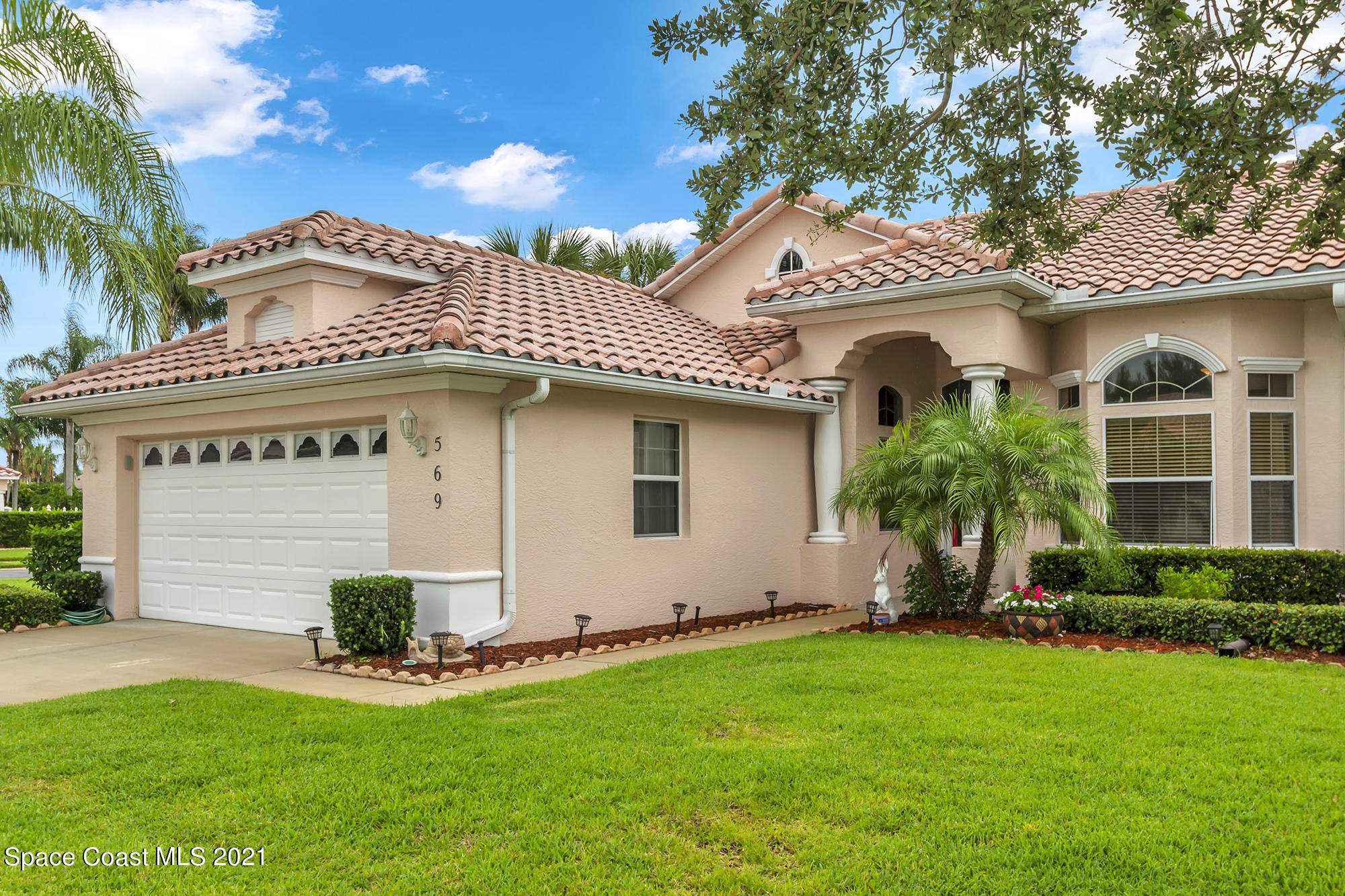 569 Renaissance Avenue Melbourne, FL 32940 - Photo 2 of 34 a front view of a house with a garden and plants