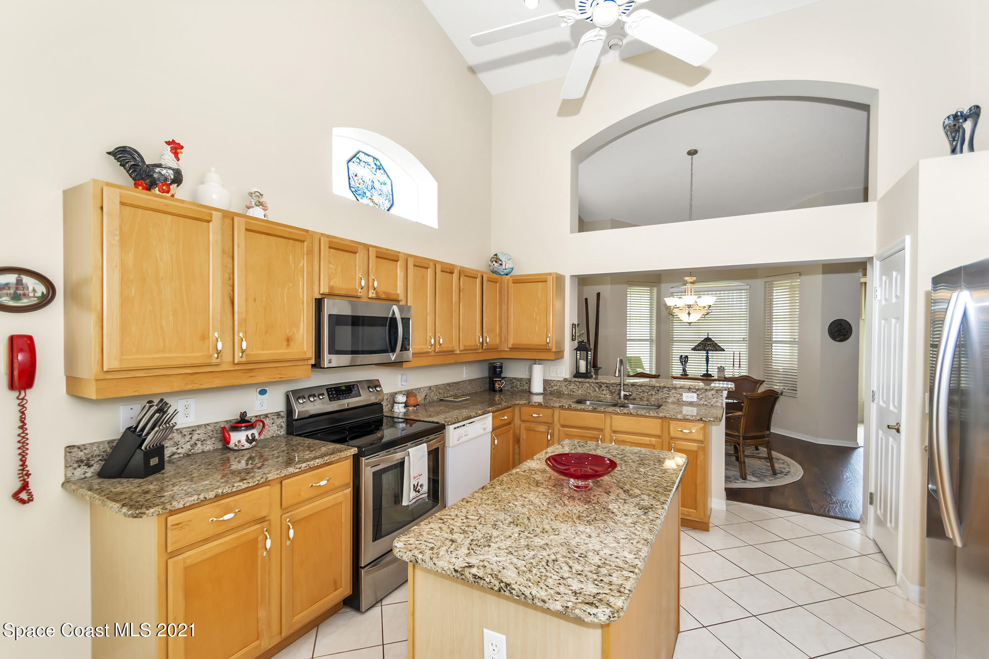 569 Renaissance Avenue Melbourne, FL 32940 - Photo 11 of 34 a kitchen with granite countertop a sink a counter top space appliances and cabinets