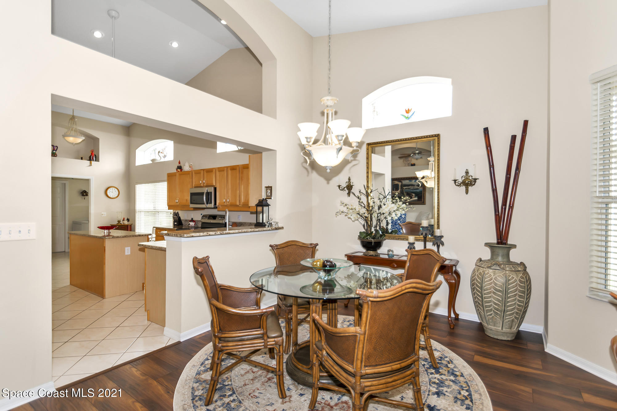 569 Renaissance Avenue Melbourne, FL 32940 - Photo 12 of 34 a dining room filled chandelier and wooden floor