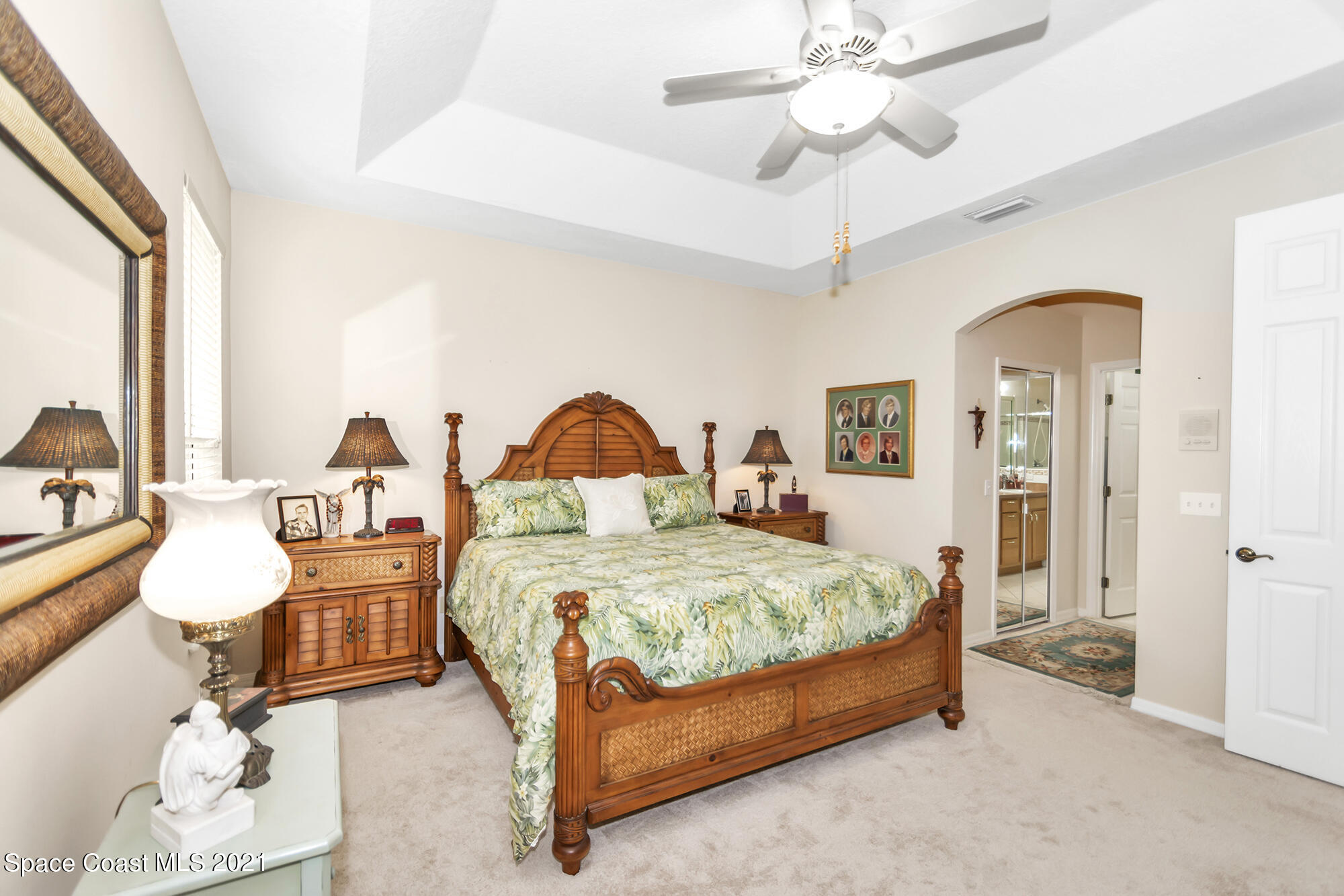 569 Renaissance Avenue Melbourne, FL 32940 - Photo 15 of 34 a bedroom with a bed a chandelier and a fireplace