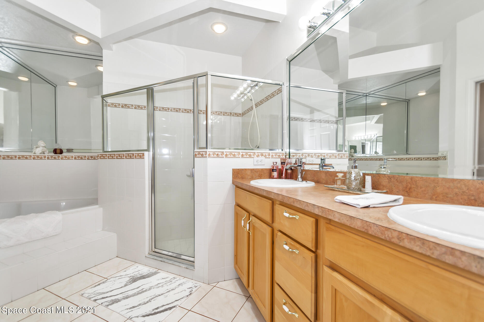 569 Renaissance Avenue Melbourne, FL 32940 - Photo 17 of 34 a bathroom with a double vanity sink a mirror and a shower