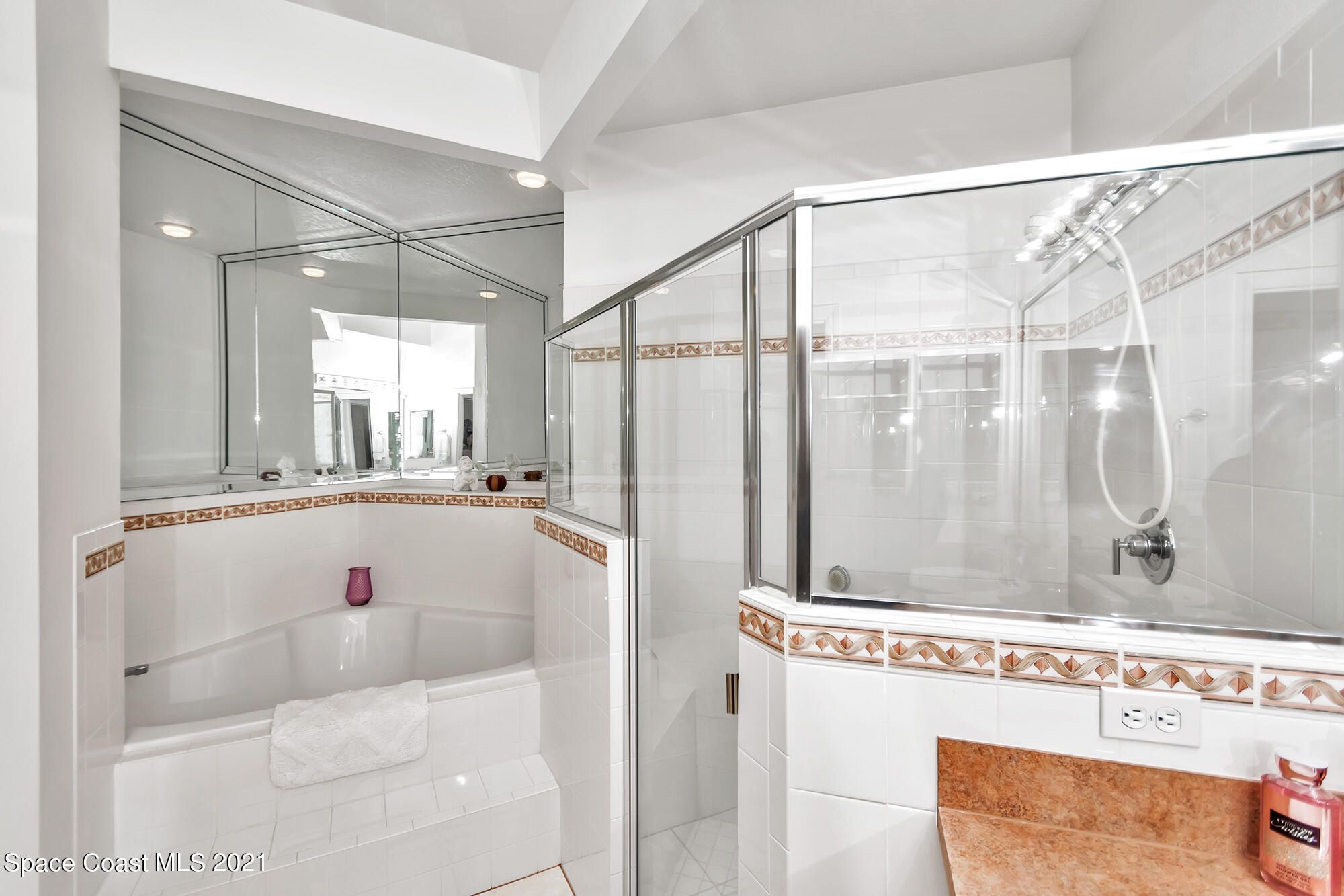 569 Renaissance Avenue Melbourne, FL 32940 - Photo 18 of 34 a bathroom with a tub a mirror and a shower