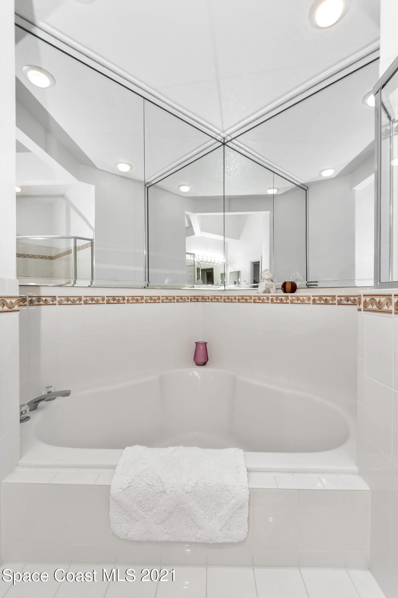569 Renaissance Avenue Melbourne, FL 32940 - Photo 19 of 34 a bathroom with a tub a mirror and a shower