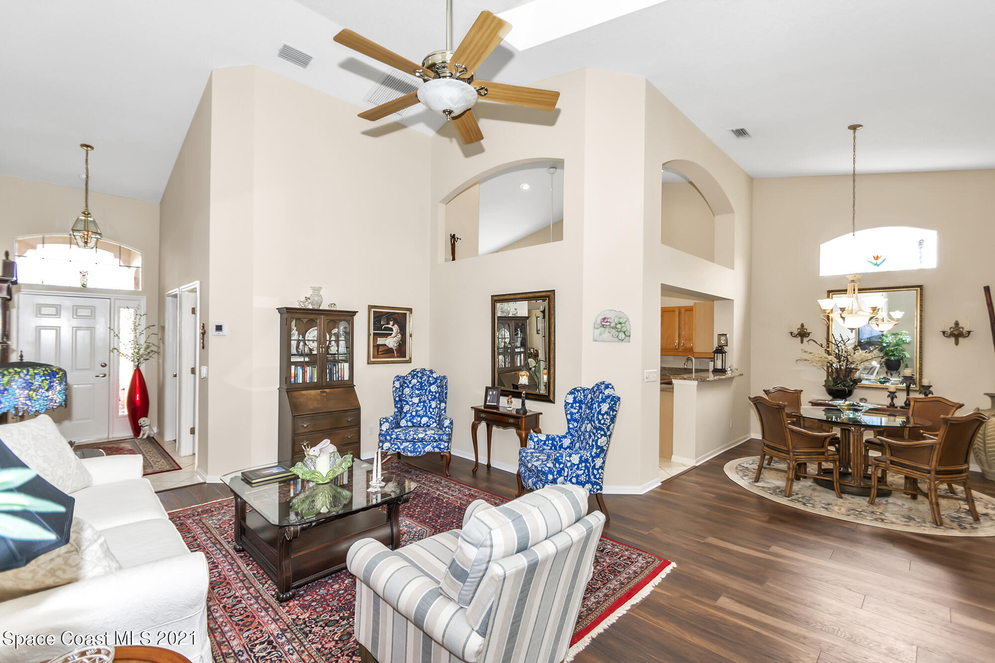 569 Renaissance Avenue Melbourne, FL 32940 - Photo 4 of 34 a living room with furniture a chandelier and a dining table