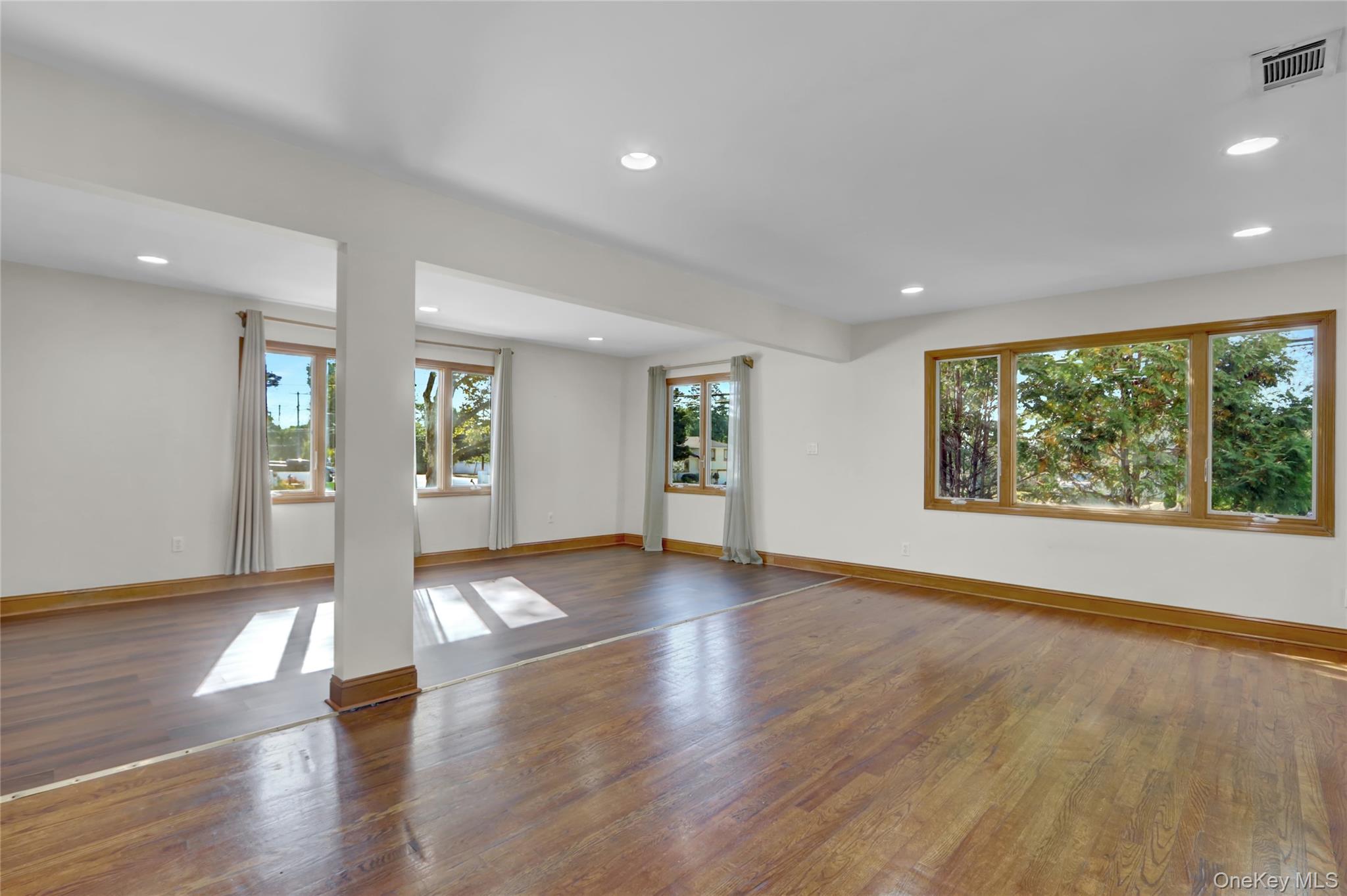 600 Plainview Road Plainview, NY 11803 - Photo 9 of 41 a view of an empty room with window and wooden floor