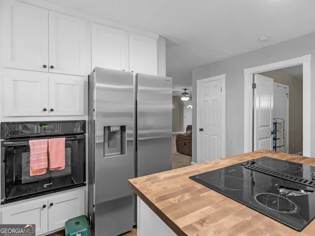 a kitchen with granite countertop white cabinets and white appliances