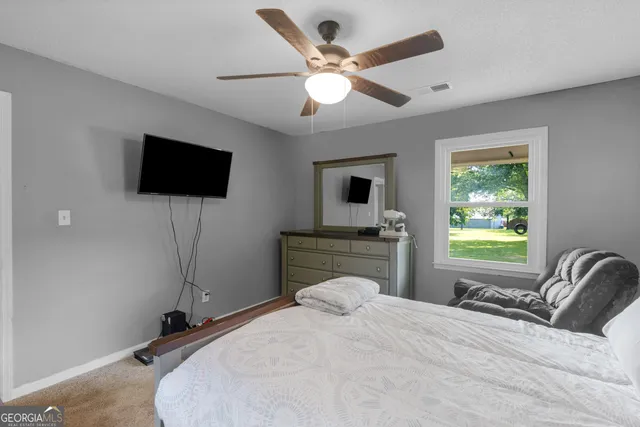 a view of a livingroom with a ceiling fan and window