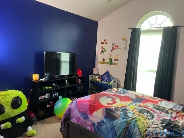 a bedroom with a bed potted plant on the dresser and flowerpot