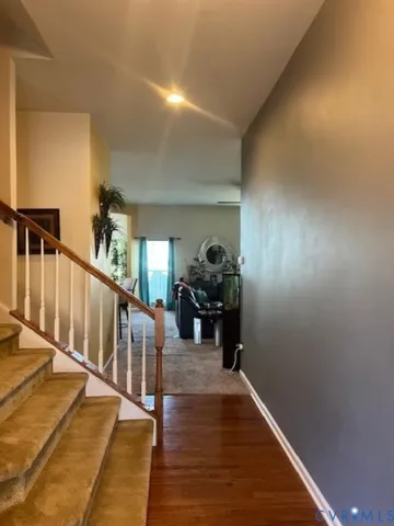 a living room with furniture a computer on the desk and a flat screen tv