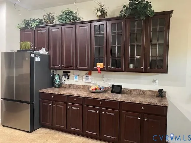 a kitchen with stainless steel appliances granite countertop a refrigerator and a sink with wooden cabinets