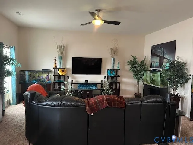 a living room with furniture a flat screen tv and a potted plant