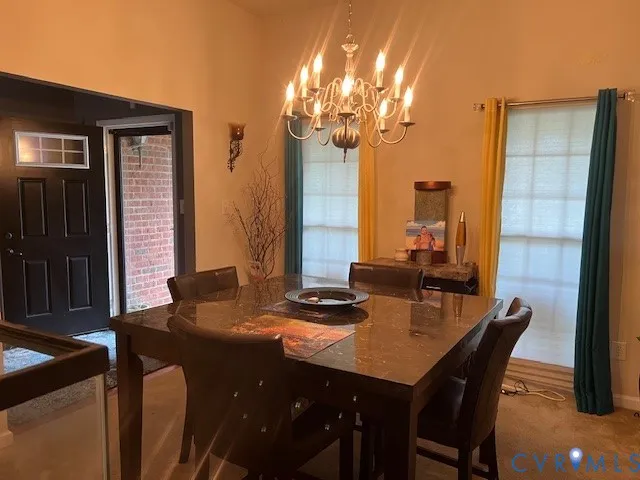 a view of a dining room with furniture and chandelier