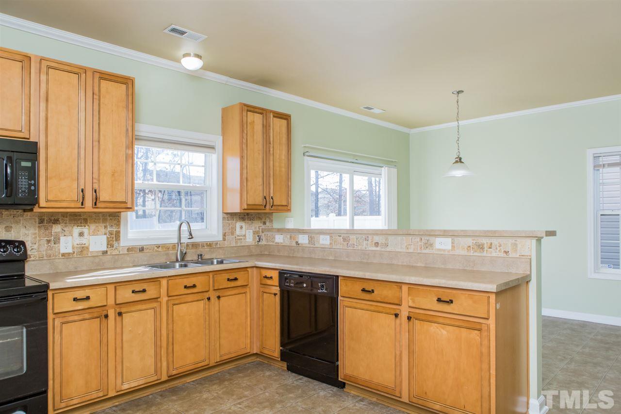 2905 Smooth Stone Trail Raleigh, NC 27610 - Photo 3 of 29 a kitchen with stainless steel appliances granite countertop a sink and dishwasher a stove a refrigerator with wooden cabinets