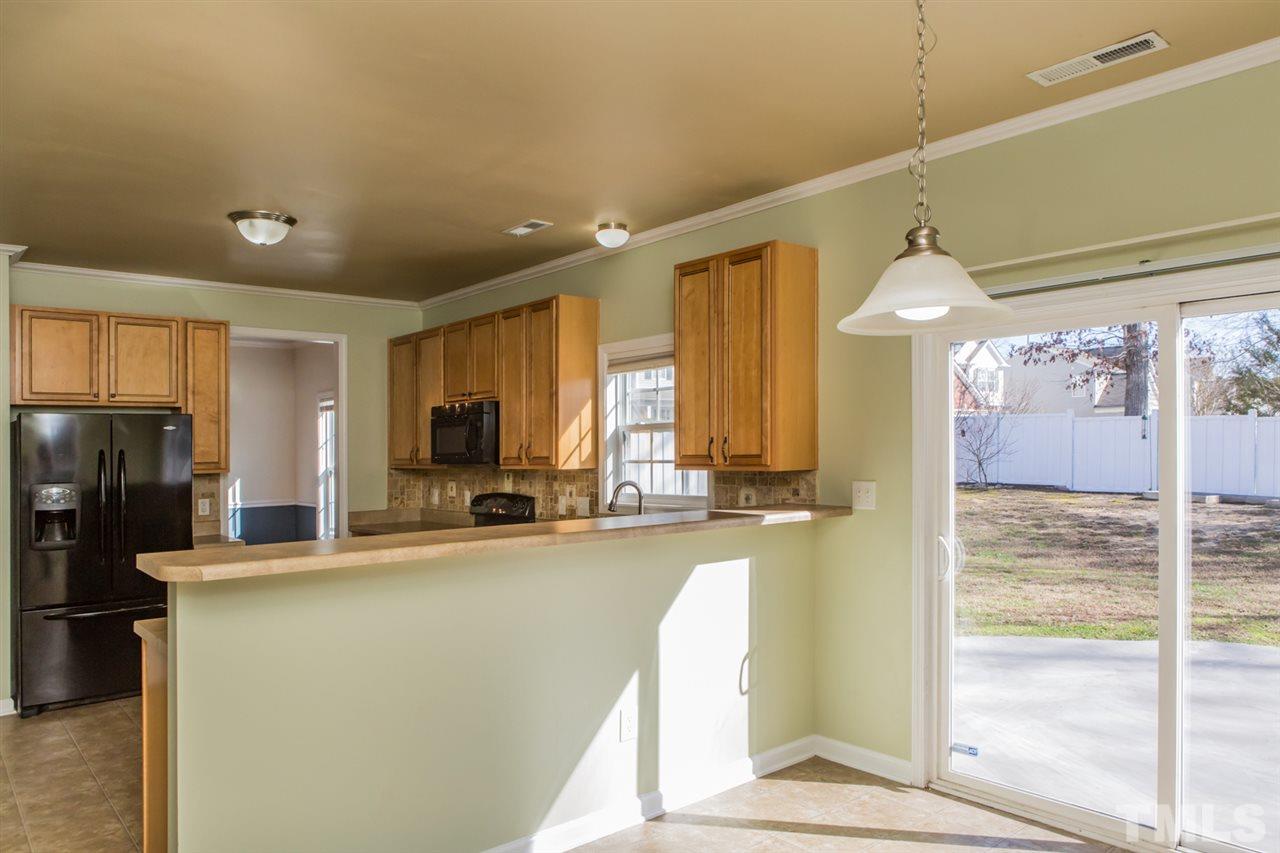 2905 Smooth Stone Trail Raleigh, NC 27610 - Photo 4 of 29 a view of a kitchen with a refrigerator a sink and a large window