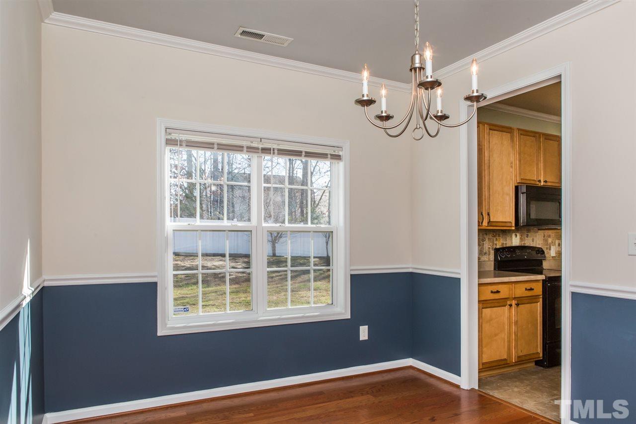 2905 Smooth Stone Trail Raleigh, NC 27610 - Photo 7 of 29 an empty room with wooden floor cabinet and windows