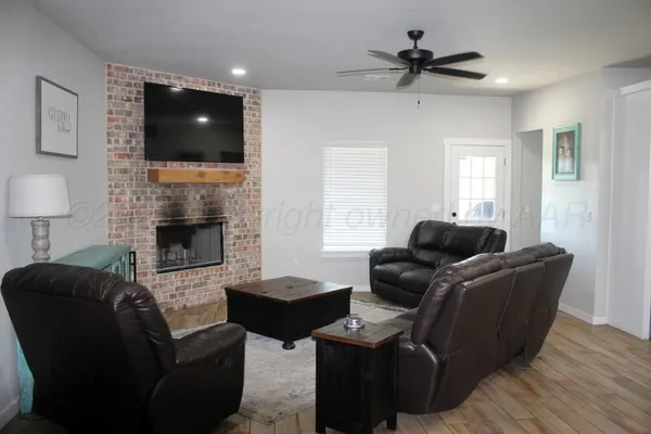 a living room with furniture a fireplace and a flat screen tv