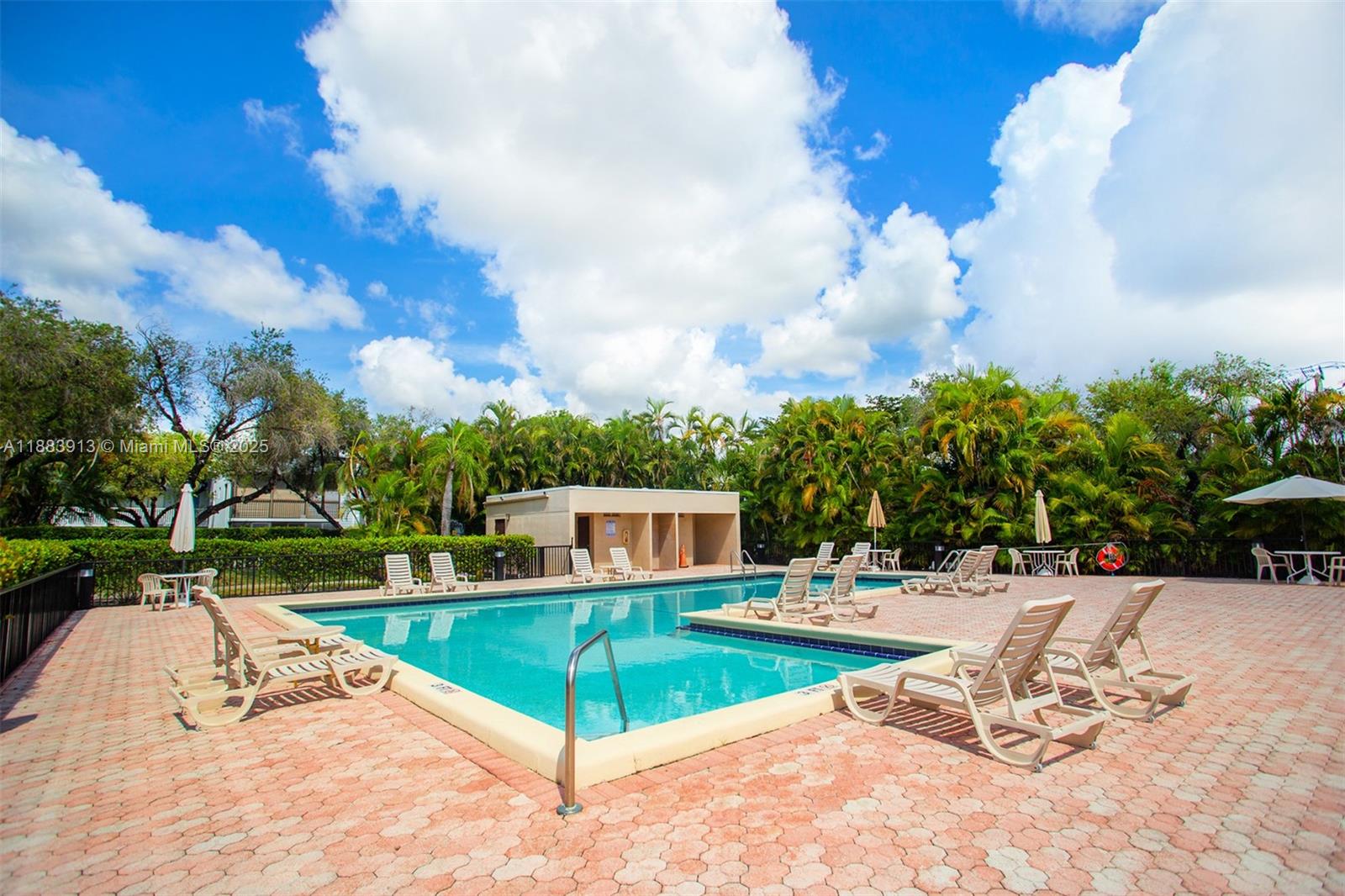 9711 West McNab Road, Unit 203 Tamarac, FL 33321 - Photo 31 of 37 a view of a swimming pool with a lounge chairs