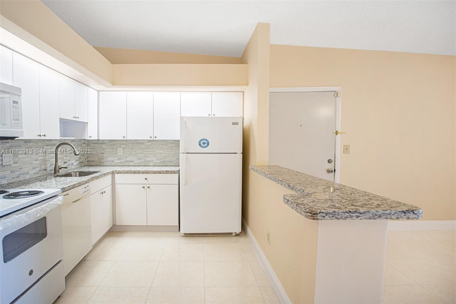9711 West McNab Road, Unit 203 Tamarac, FL 33321 - Photo 7 of 37 a kitchen with a sink stove and cabinets