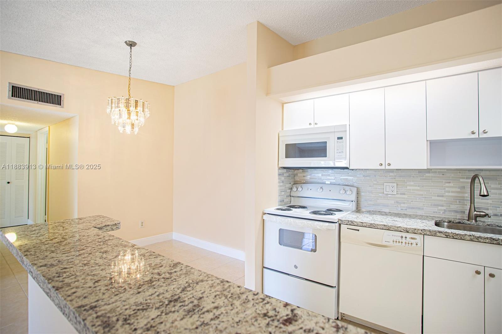 9711 West McNab Road, Unit 203 Tamarac, FL 33321 - Photo 9 of 37 a kitchen with a stove a sink and a refrigerator