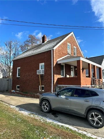 a front view of a house with a parking space